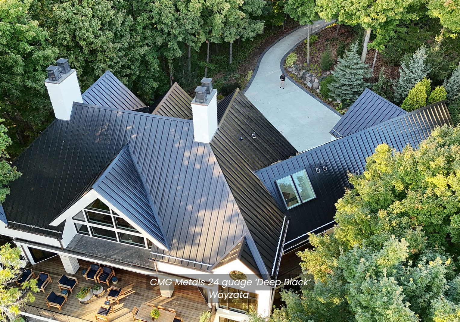 CMG Metals Wayzata Wayzata, Minnesota home with newly installed 24-gauge standing seam steel roof by Evergreen Construction, featuring deep black panels, 14 roof planes, and steep 12/12 pitch, showcasing precision craftsmanship and durability